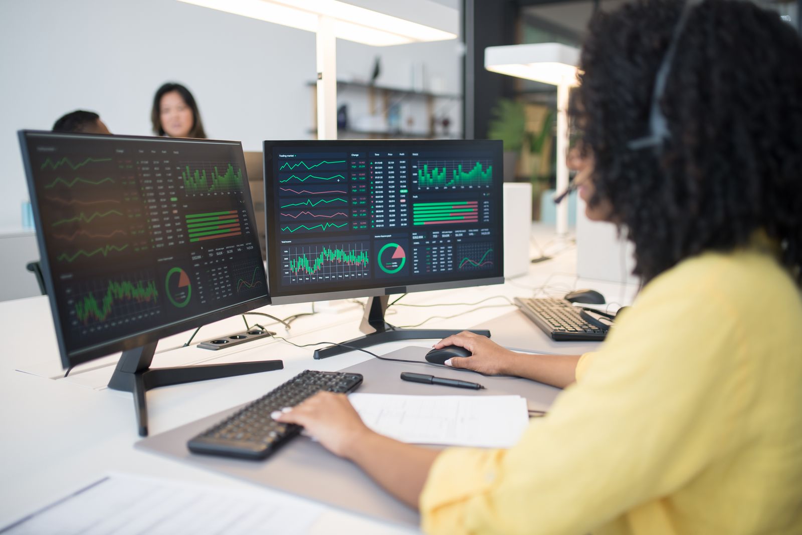 Analyst reviewing data on multiple screens